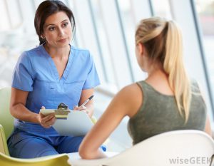 female-nurse-talking-to-woman-with-clipboard